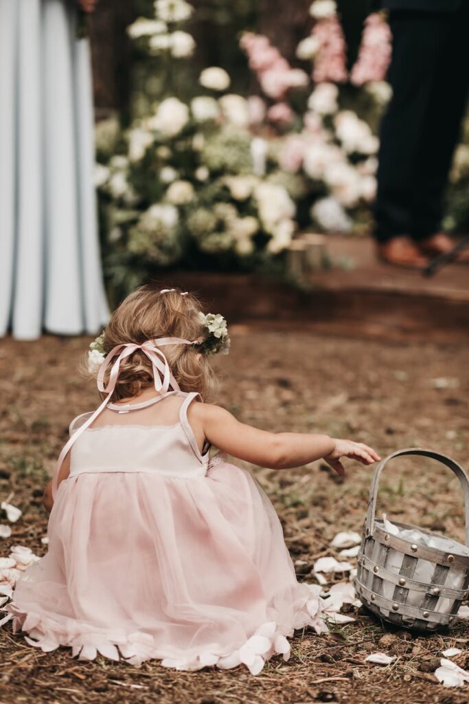 little girl picking up rose petals 