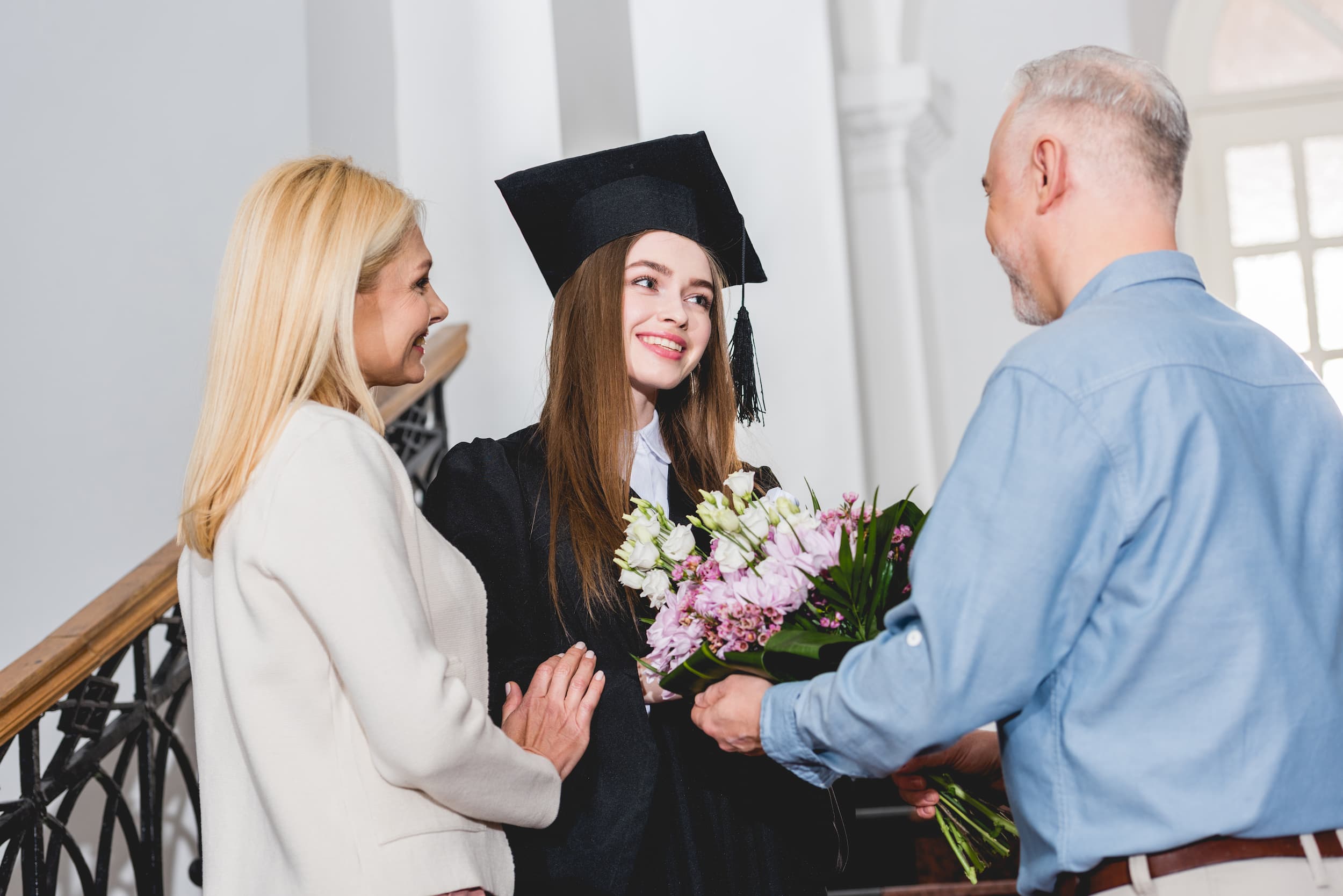  Graduation flowers presented to graduate by proud family celebrating academic achievement